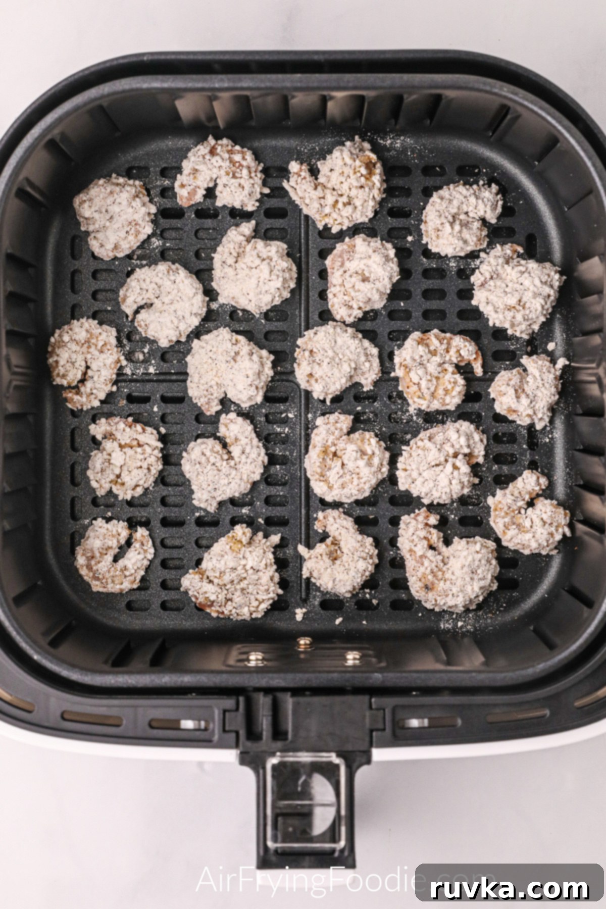 Crispy Air Fryer Bang Bang Shrimp 5 Breaded shrimp in the basket of the air fryer, ready to cook.
