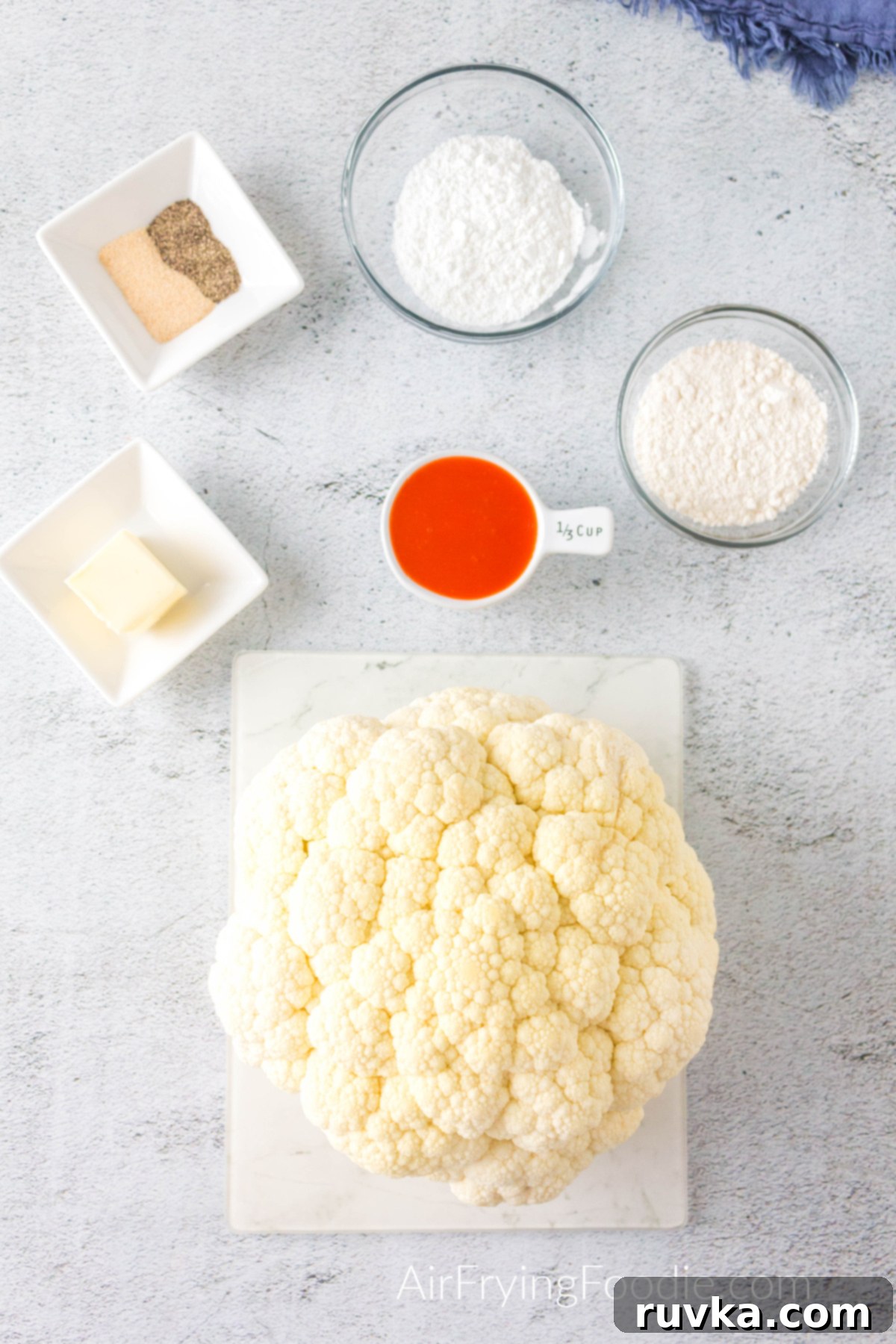 Spicy Air Fryer Cauliflower Wings 3 Ingredients needed to make buffalo cauliflower bites in the air fryer - set out on a table.
