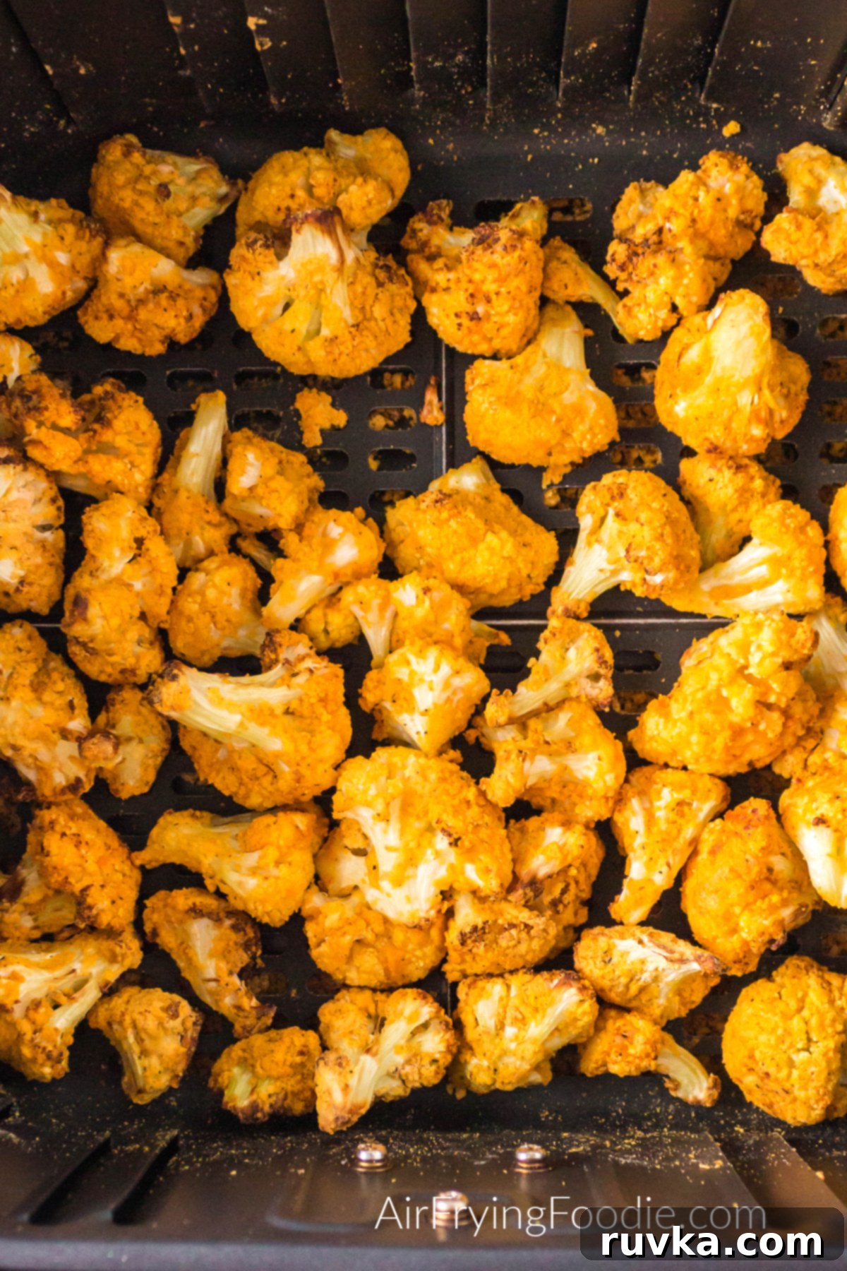 Spicy Air Fryer Cauliflower Wings 4 Air fried buffalo cauliflower bites in the basket of the air fryer.