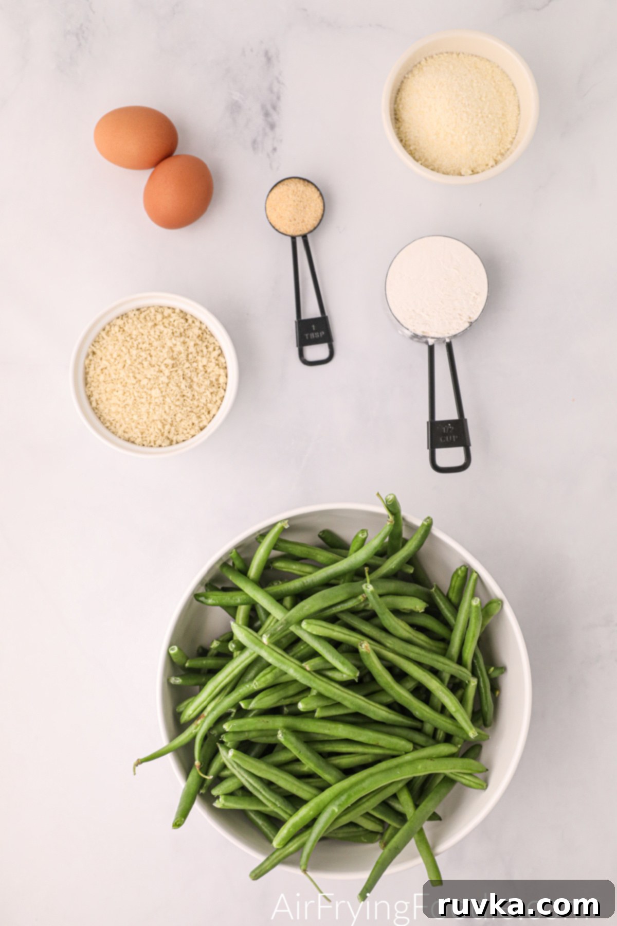 Air Fryer Crispy Green Bean Sticks 3 Bowls of fresh green beans, whisked eggs, flour, and the Parmesan breadcrumb mix, ready for preparing air fryer green bean fries.