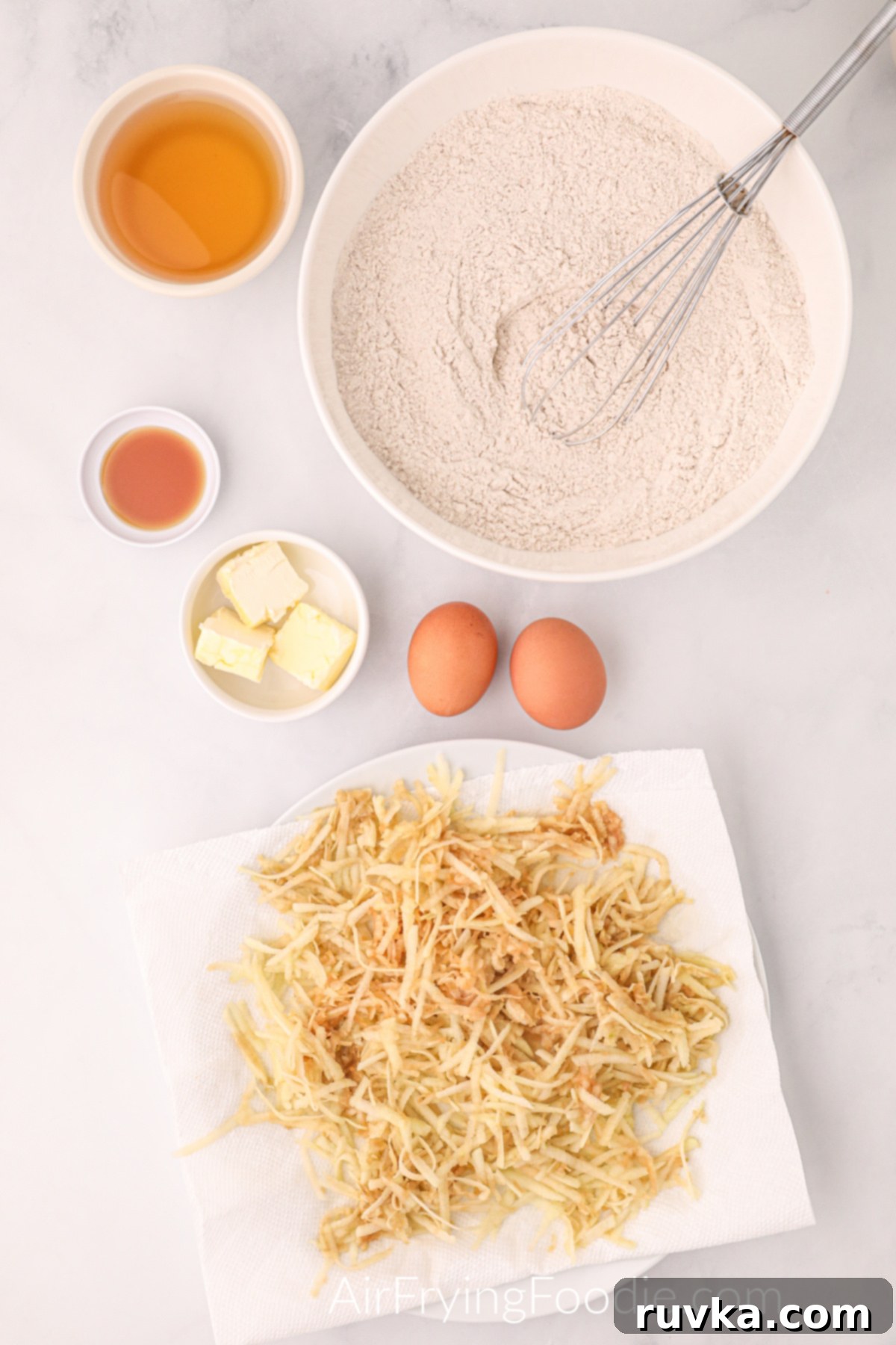 Easy Air Fryer Apple Fritters 4 Freshly shredded Granny Smith apples and other dry ingredients for apple fritters laid out on a table, ready for mixing.
