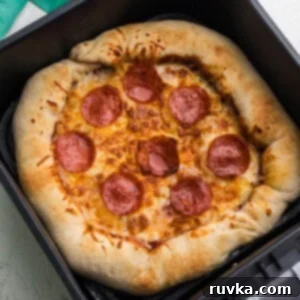 Crispy Air Fryer Pizza 11 Air fryer pizza that has been fully cooked and is in the basket of the air fryer.