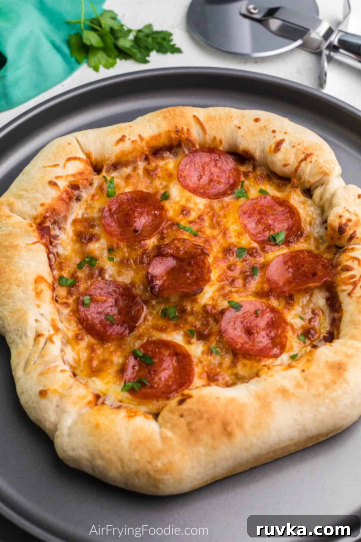 Crispy Air Fryer Pizza 3 A freshly baked Air Fryer pizza, perfectly golden with melted cheese, placed on a wooden serving plate, ready to be cut and enjoyed.