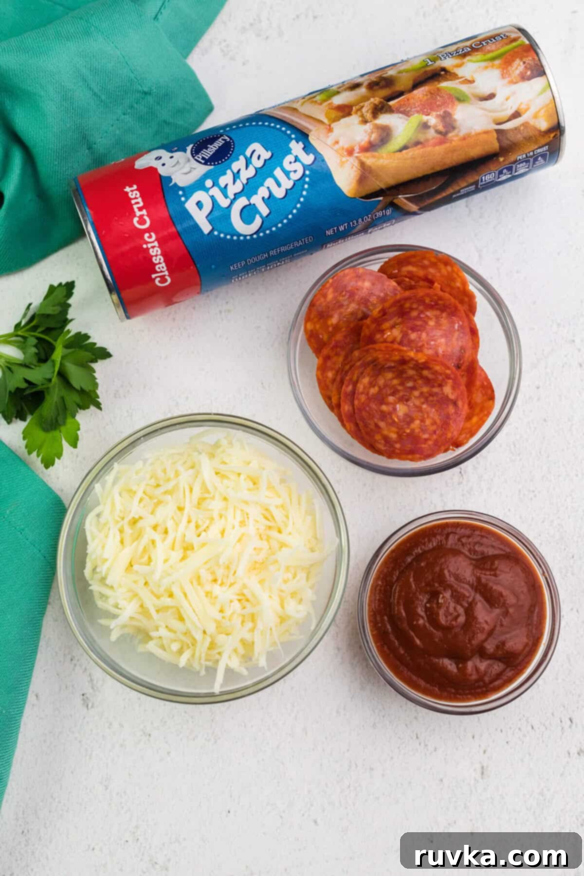 Crispy Air Fryer Pizza 4 A vibrant selection of fresh air fryer pizza ingredients including mozzarella, pizza sauce, basil, and a rolled-out pizza dough.