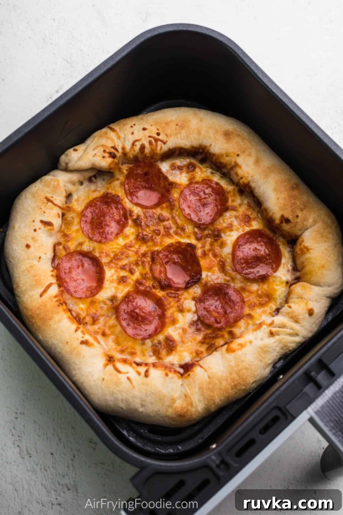 Crispy Air Fryer Pizza 8 A perfectly cooked Air Fryer pizza, ready to be removed from the basket and served.