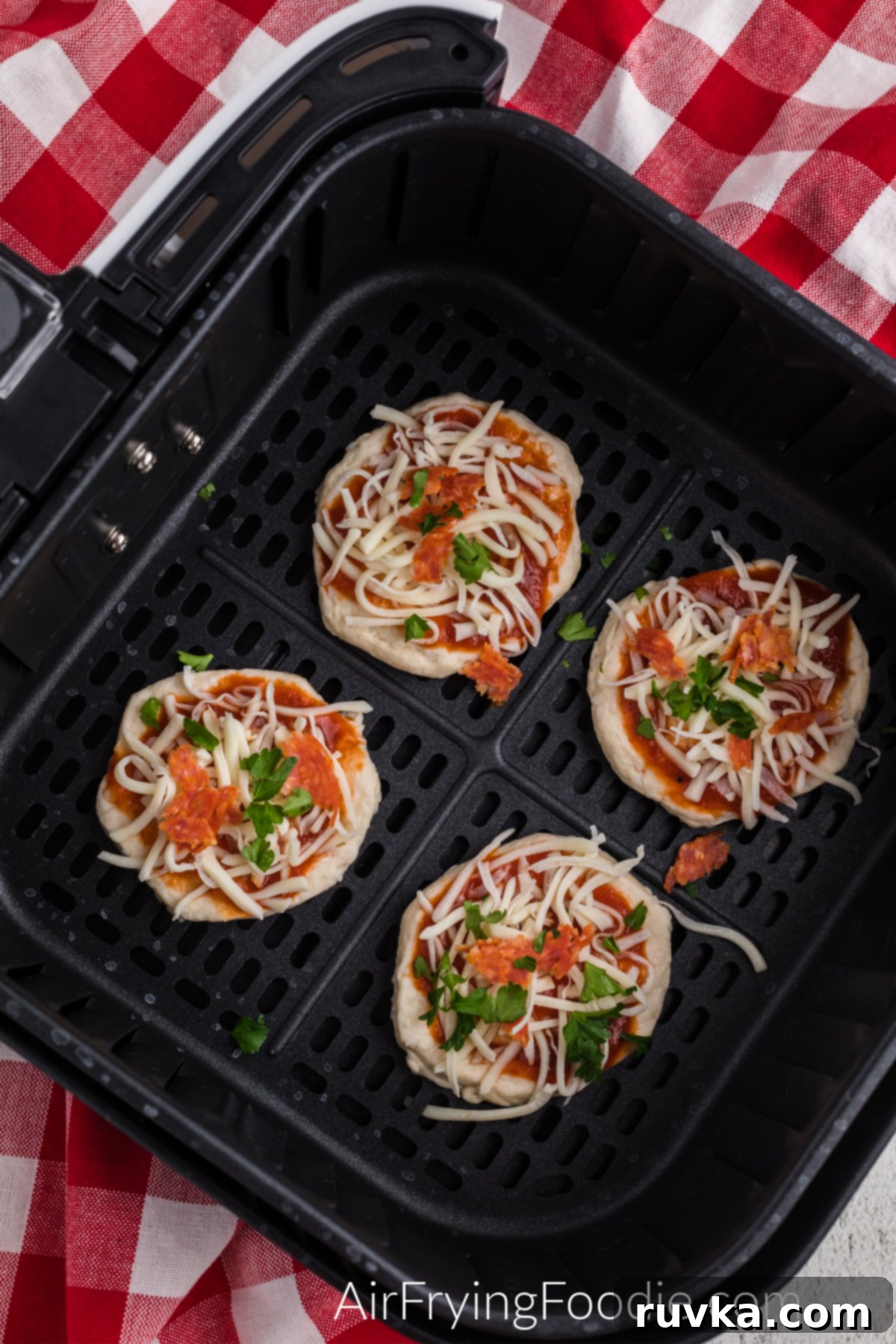 Crispy Air Fryer Pizza Bites 5 Biscuit dough topped with pizza sauce and toppings.