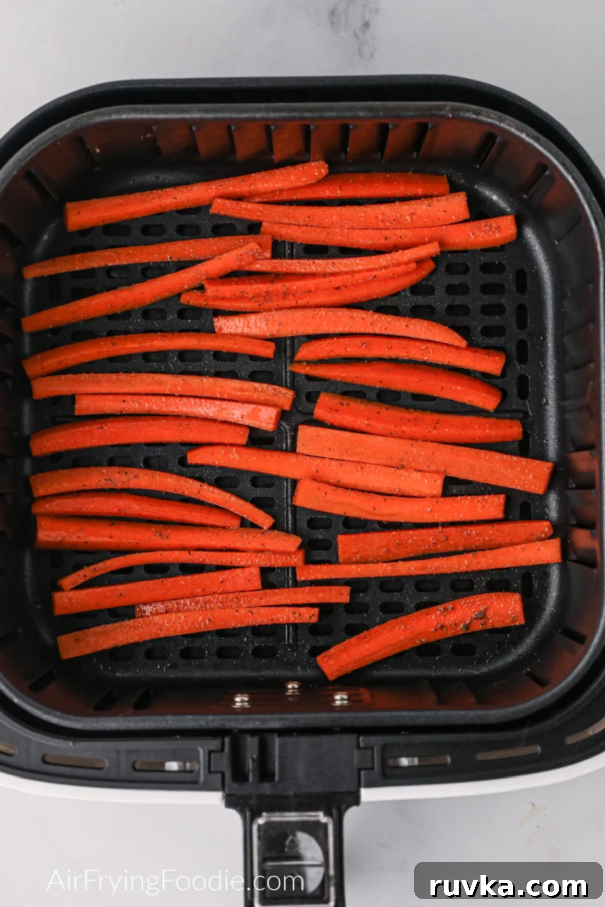 Crispy Air Fryer Carrot Fries 5 Carrot fries cut and placed in the air fryer basket.