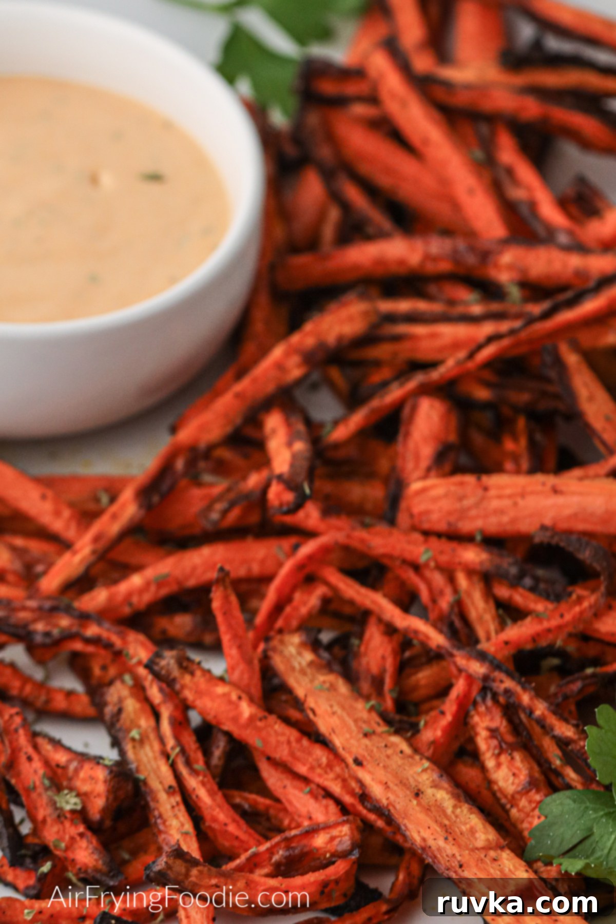 Crispy Air Fryer Carrot Fries 6 Air fried carrot fries on a plate with dipping sauce, ready to eat.