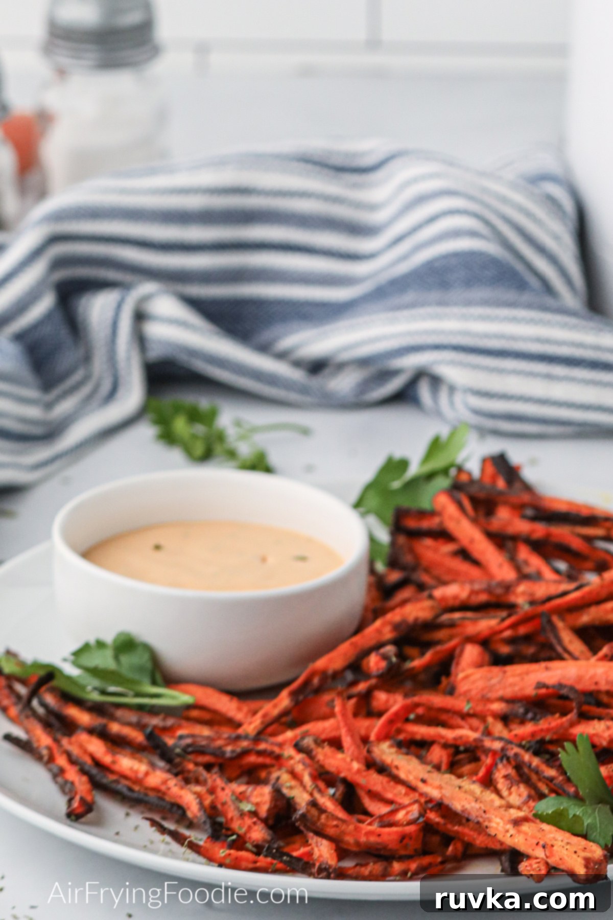 Crispy Air Fryer Carrot Fries 7 Air fryer carrot fries on a white plate with dipping sauce to serve.