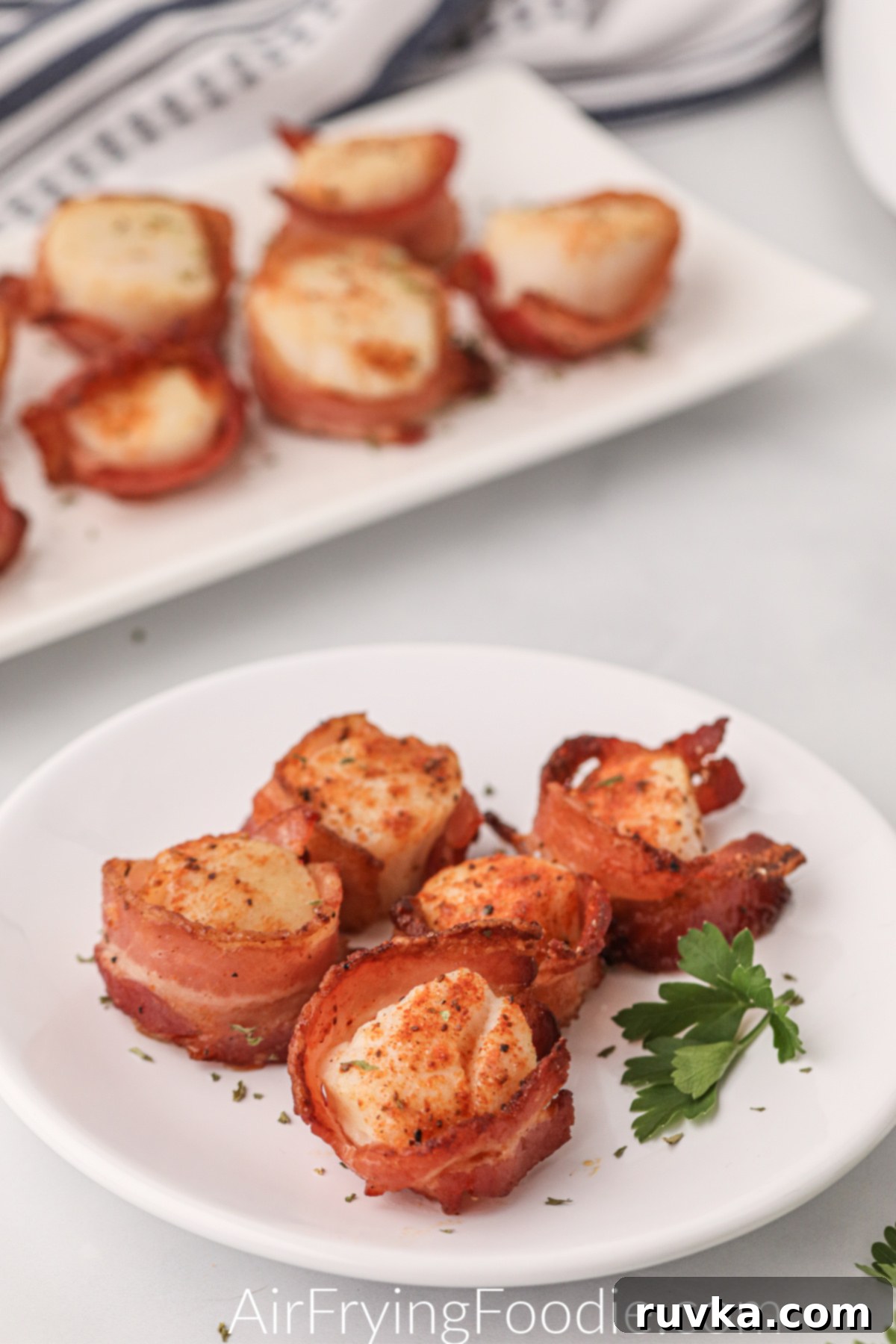 Crispy Air Fryer Bacon Wrapped Scallops 7 Air fryer bacon wrapped scallops on a white plate ready to serve.