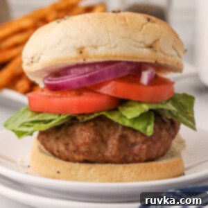 Crispy Air Fryer Turkey Burgers 9 Air fryer turkey burger patty on a bun with lettuce, tomato, and onion.