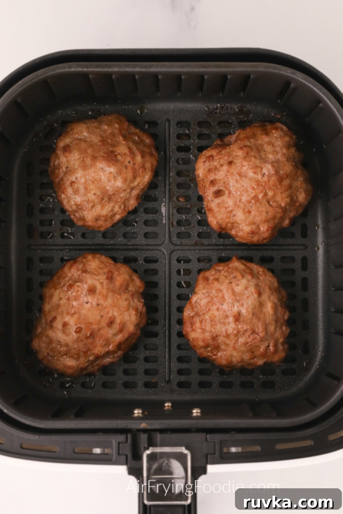 Crispy Air Fryer Turkey Burgers 6 Fried Turkey Burgers in the basket of the air fryer.
