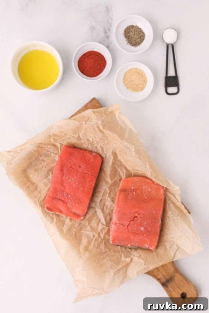 Crispy Air Fryer Salmon 3 Ingredients to make salmon with seasonings measured on the white table