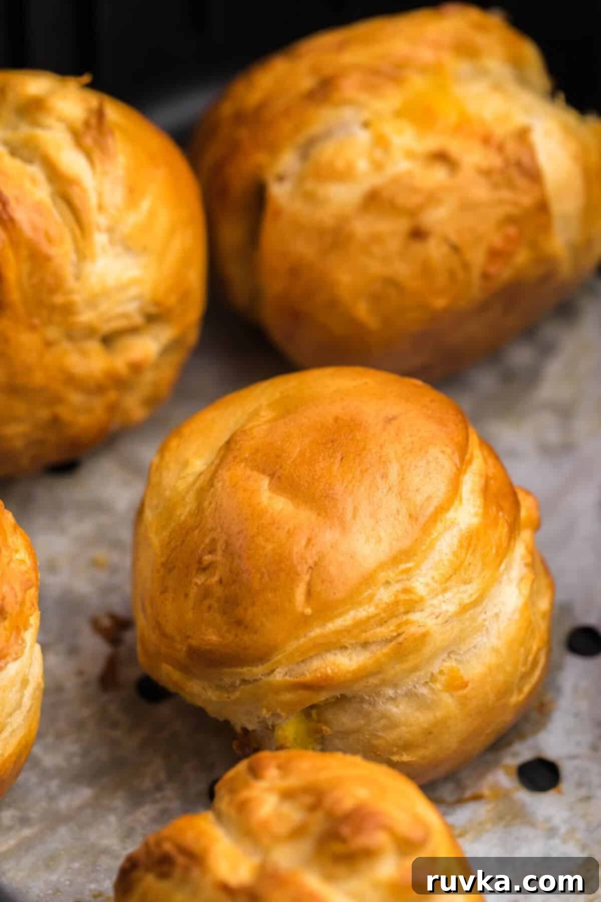 Air Fryer Biscuit Surprises 4 Biscuit bombs in the basket of the air fryer, cooked to a perfect golden brown.