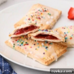 Air Fried Pop Tart Perfection 11 Golden pastries filled with strawberry jam, on a white plate.