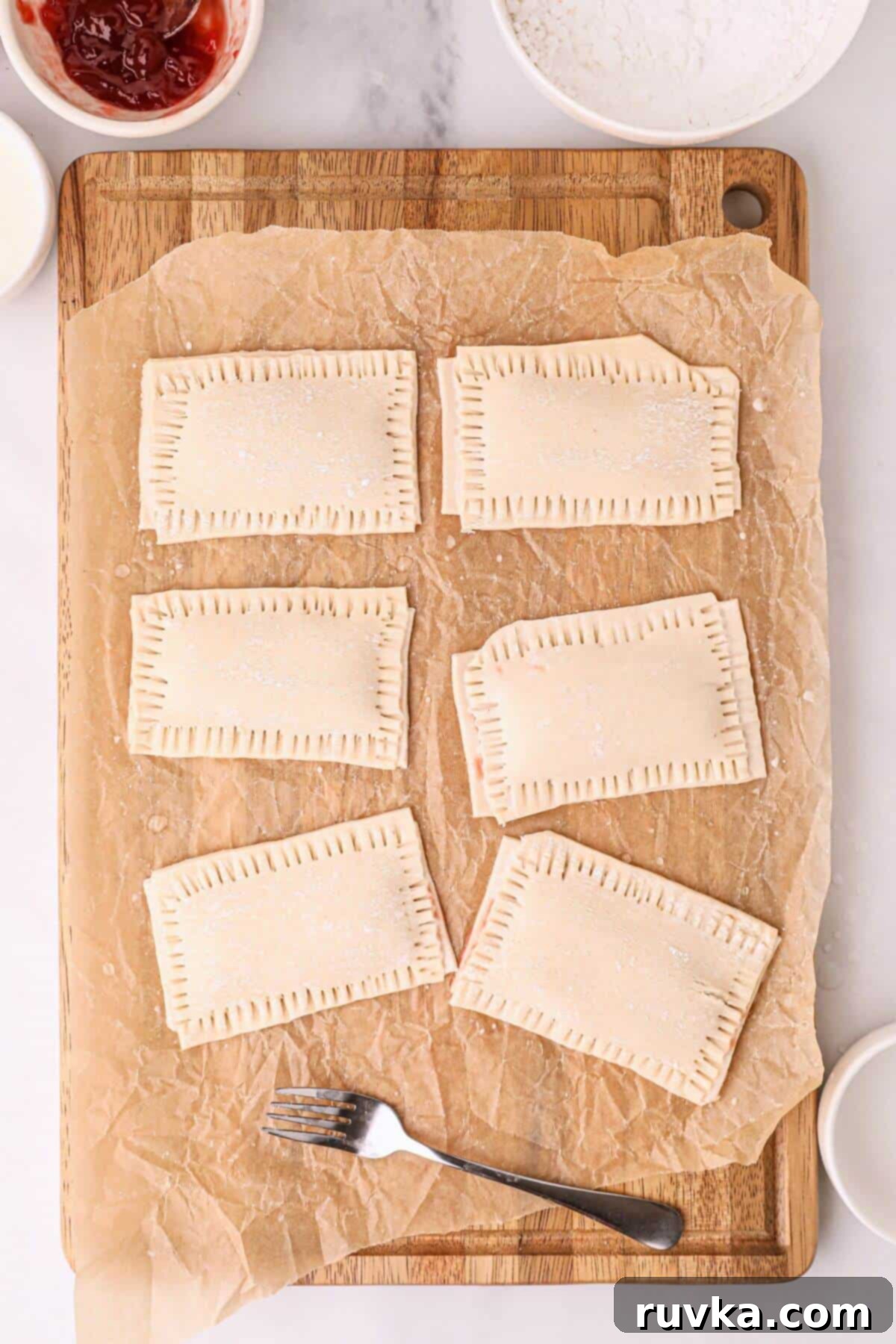 Air Fried Pop Tart Perfection 6 Pastry rectangles filled with jam, with corners pinched and sealed with a fork.