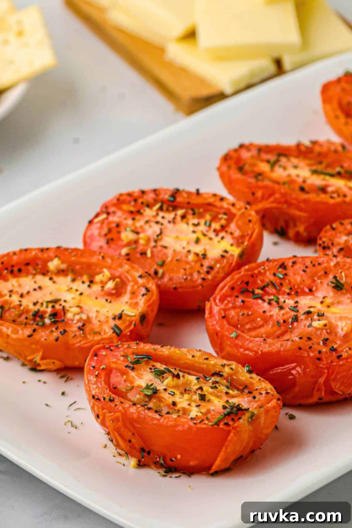 Air Fryer Roasted Tomatoes 2 Red juicy tomatoes with seasonings on top after being air fried.