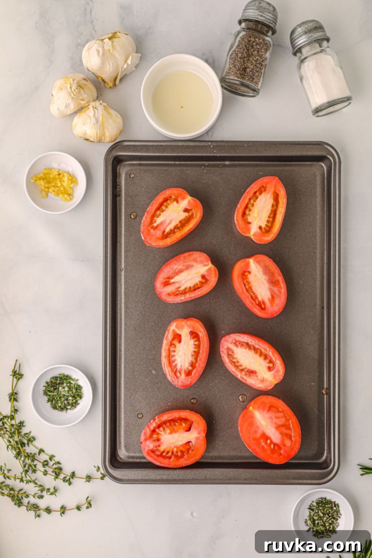 Air Fryer Roasted Tomatoes 4 tomatoes sliced in half on a baking sheet.