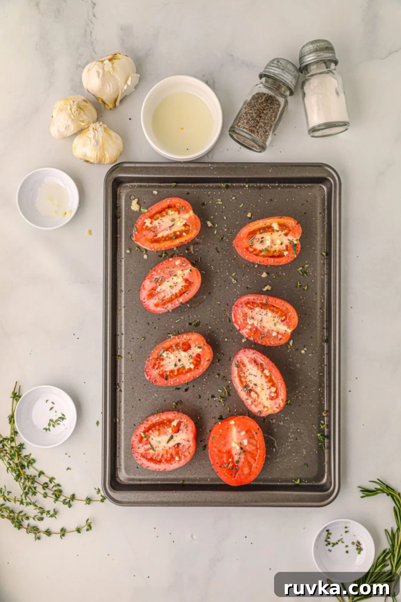 Air Fryer Roasted Tomatoes 5 Sliced tomatoes on a baking sheet being drizzled with olive oil and seasonings
