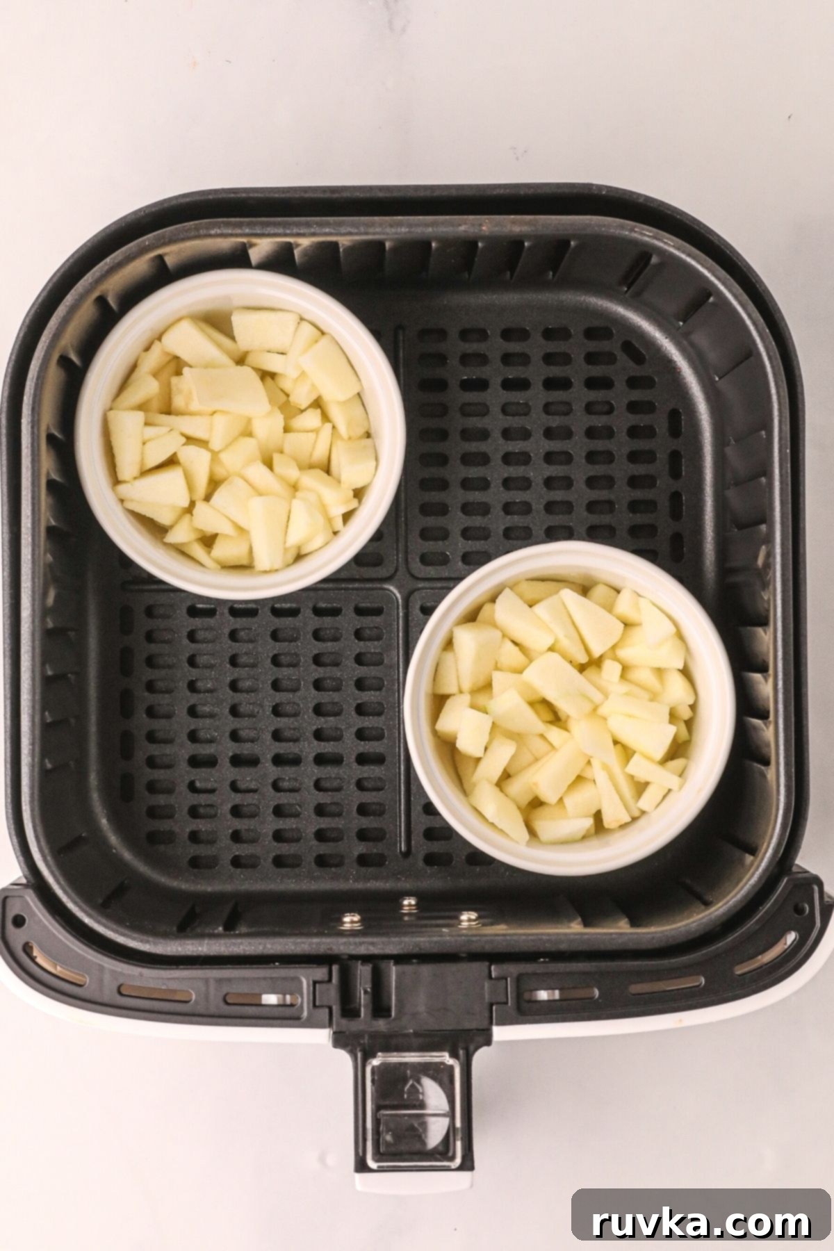 Easy Air Fryer Apple Crisp 5 apple mixture placed in ramekins and then in placed in an air fryer basket before cooking