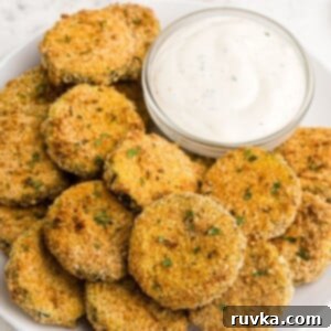 Crispy Air Fryer Zucchini Crisps 10 Golden zucchini on a white plate served with a dipping sauce