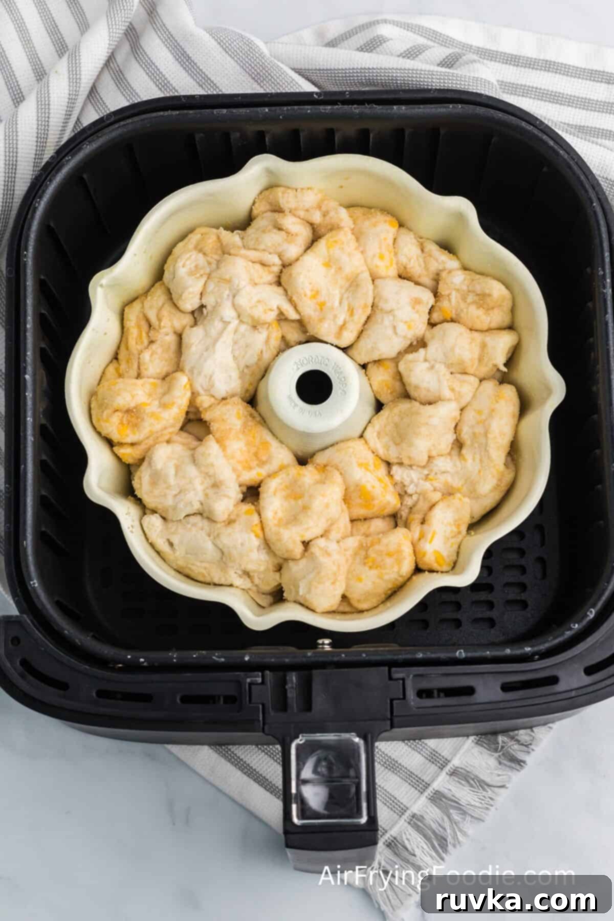 Air-Fried Gooey Cinnamon Pull-Apart 6 biscuit dough and sugar placed in a bundt pan in the basket of the air fryer.