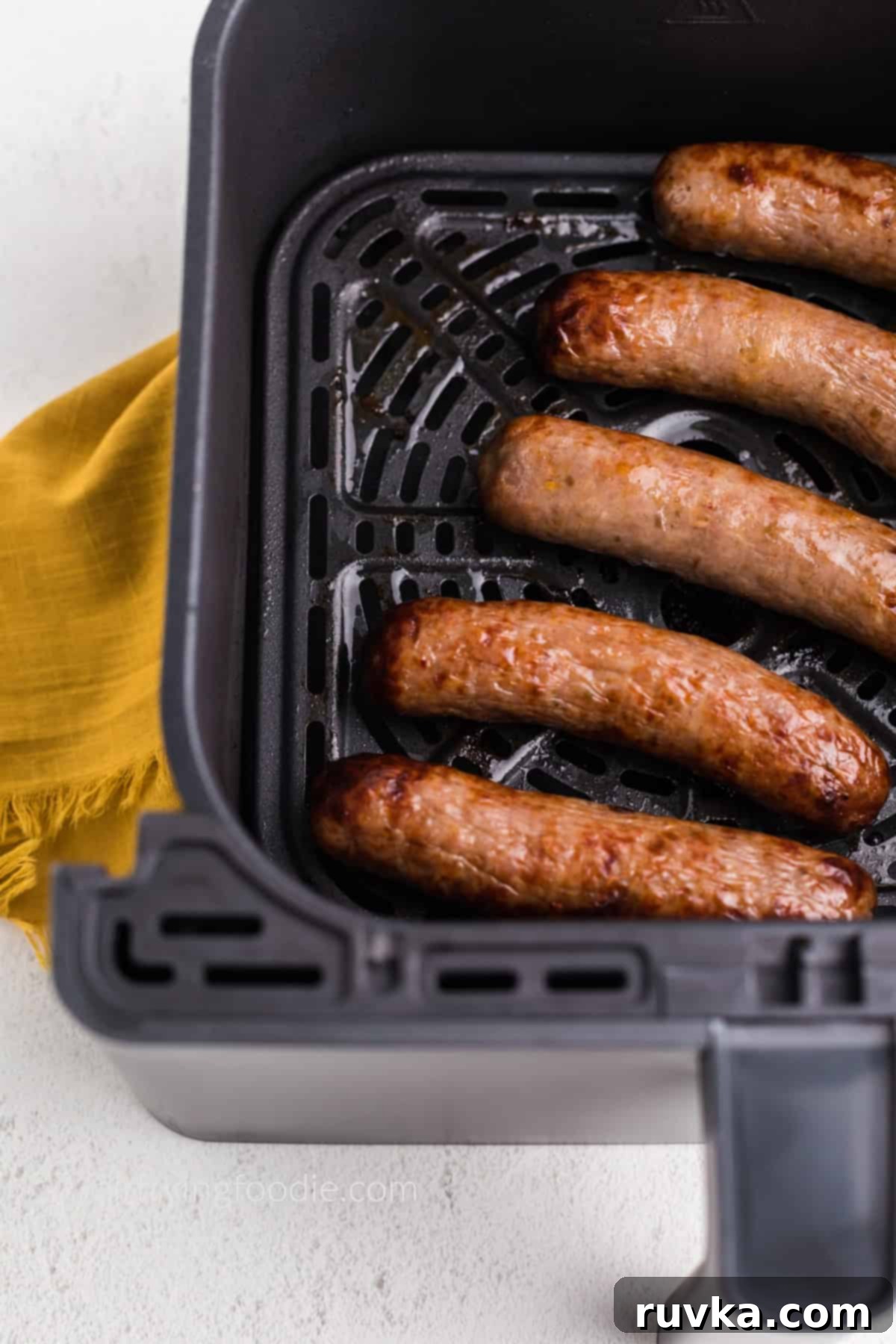Crispy Air Fryer Italian Sausage 5 Close up photo of Italian sausage in the air fryer basket, ready to serve.