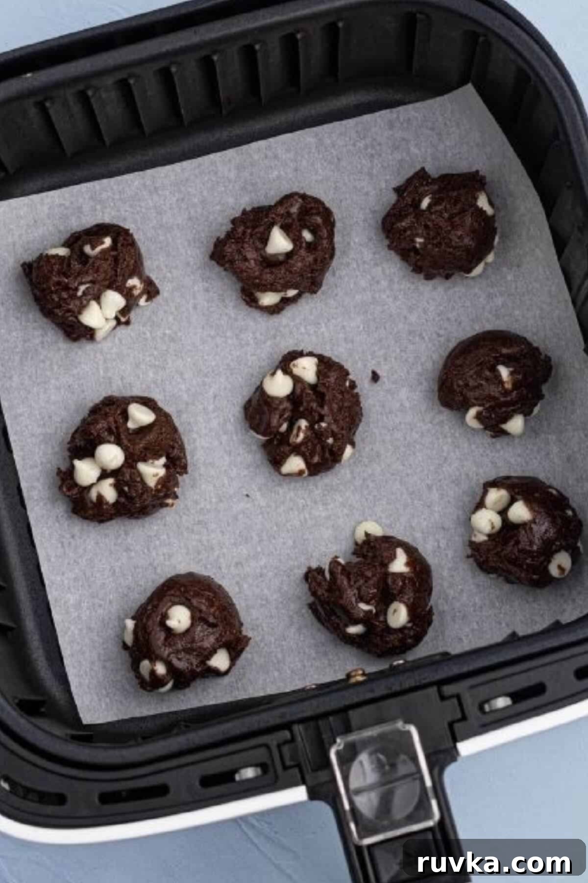 Air Fryer Cake Mix Cookies 3 cake mix dough scooped onto a paper liner in the basket of the air fryer.