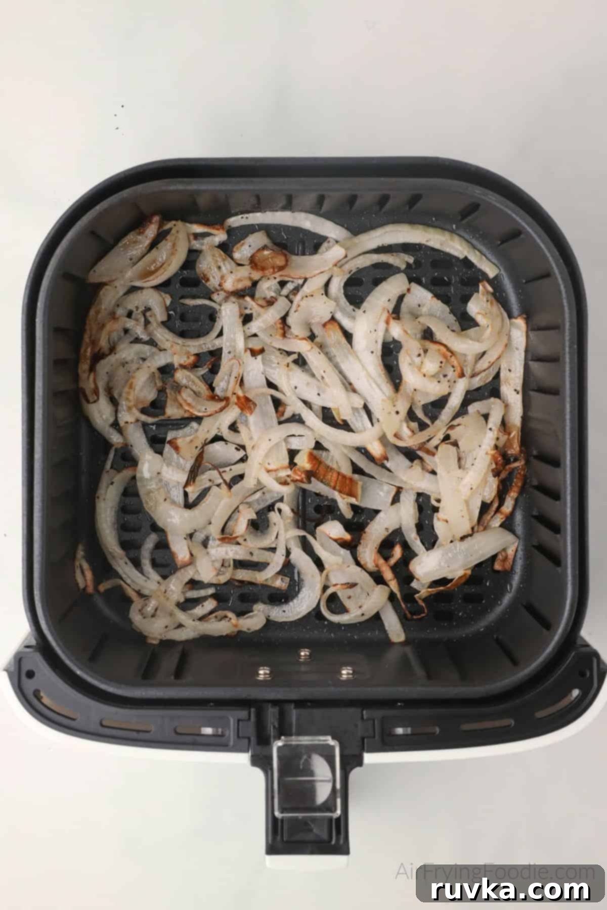 Crispy Air-Fried Onions 7 Crispy air fried onions in the basket of the air fryer.