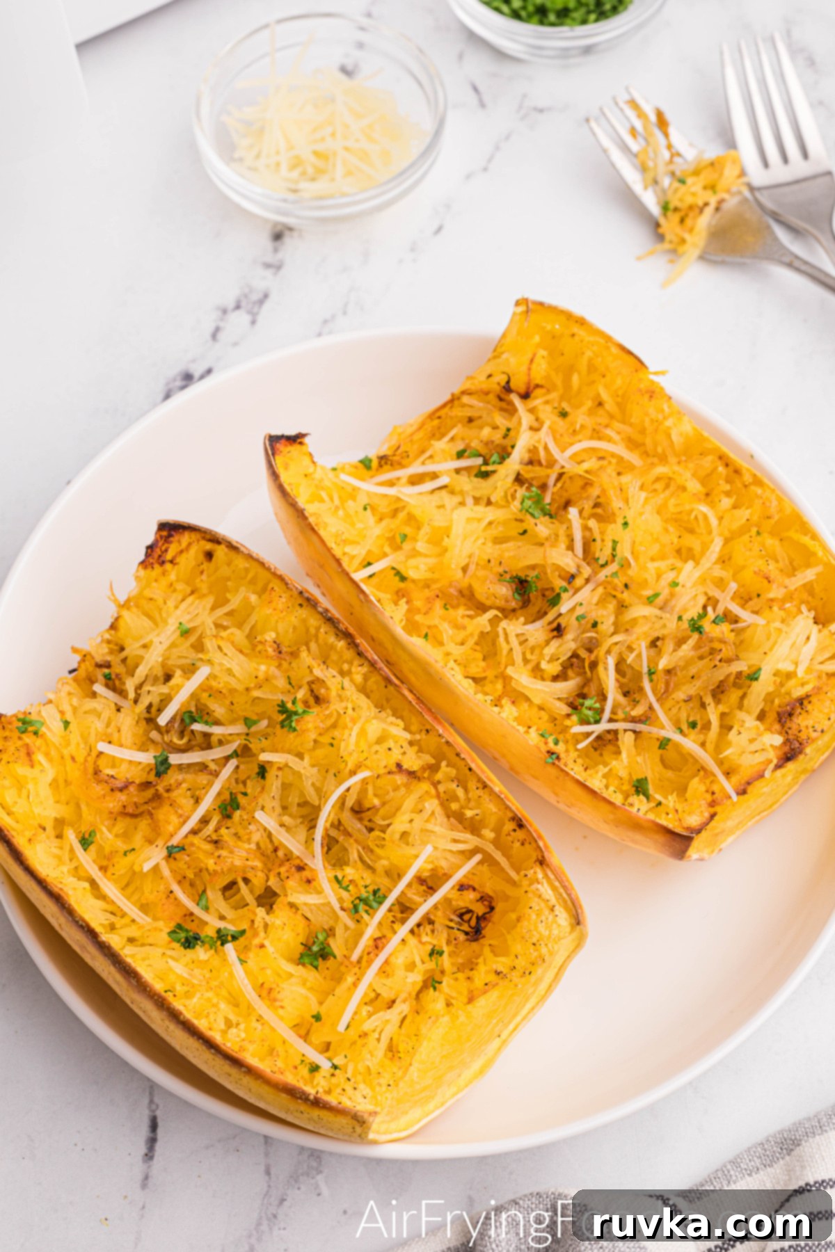 Perfect Air Fryer Spaghetti Squash 11 Spaghetti squash on a white plate, fluffed and ready to eat.