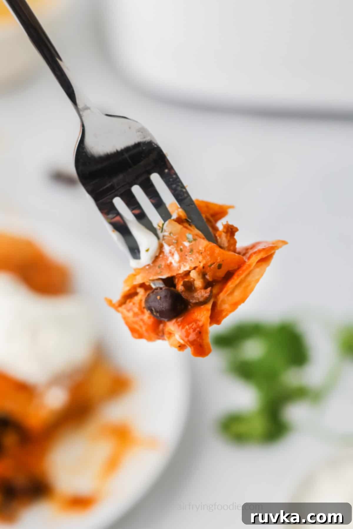 Easy Air Fryer Enchiladas 10 Bite of air fried chicken enchiladas on a fork.