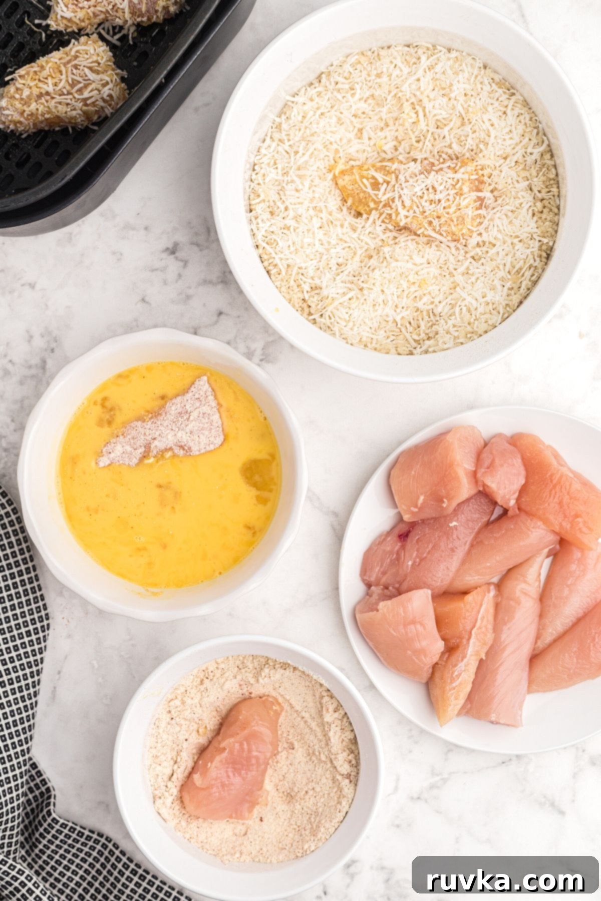 Crispy Air Fryer Coconut Chicken 5 Chicken being dredged in flour, then eggs, then panko and coconut before being placed in air fryer