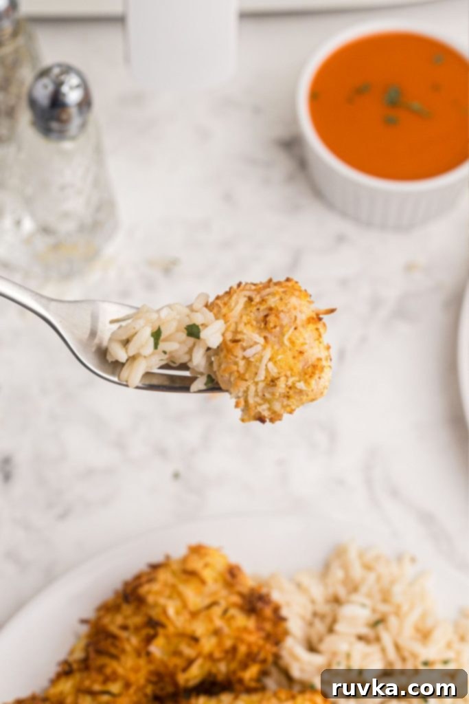 Crispy Air Fryer Coconut Chicken 8 Up close fork bite with piece of coconut chicken and white rice