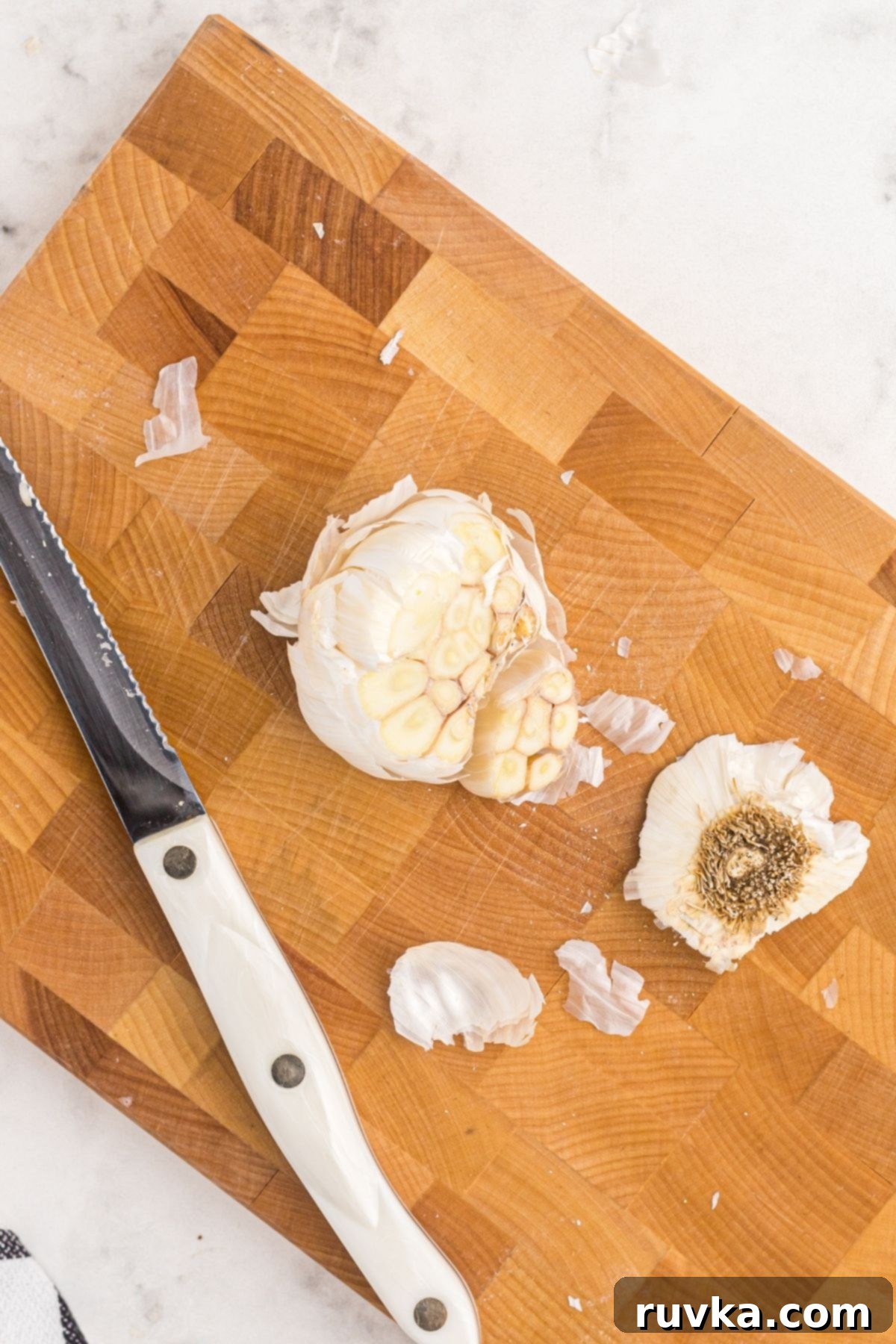 Perfect Air Fryer Roasted Garlic 4 Garlic bulb with top cut off on a wooden cutting board