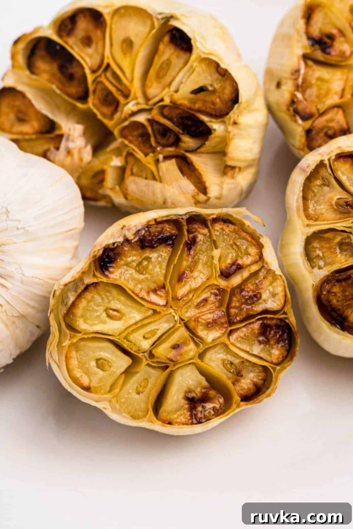 Perfect Air Fryer Roasted Garlic 7 Golden roasted garlic heads on a marble table