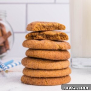 Golden Spiced Air Fryer Snaps 12 Stacked gingersnap cookies in front of milk and cinnamon sticks