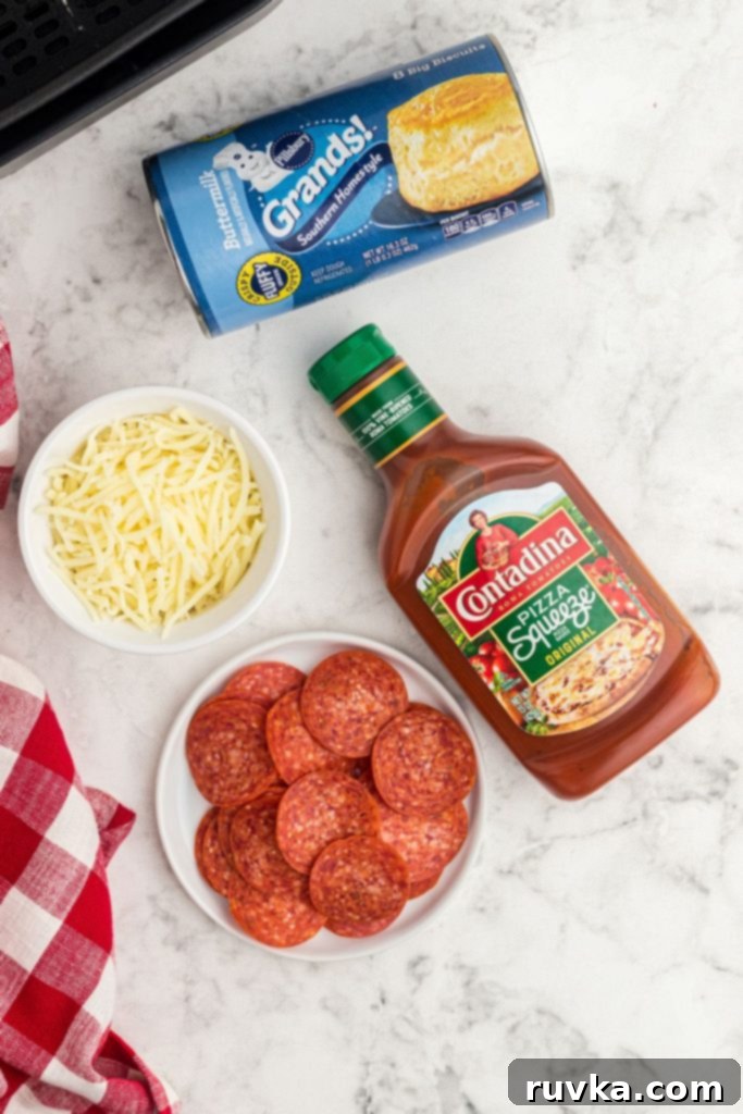 Air Fryer Pizza Poppers 3 Ingredients needed to make pizza bombs in the air fryer on a white marble table