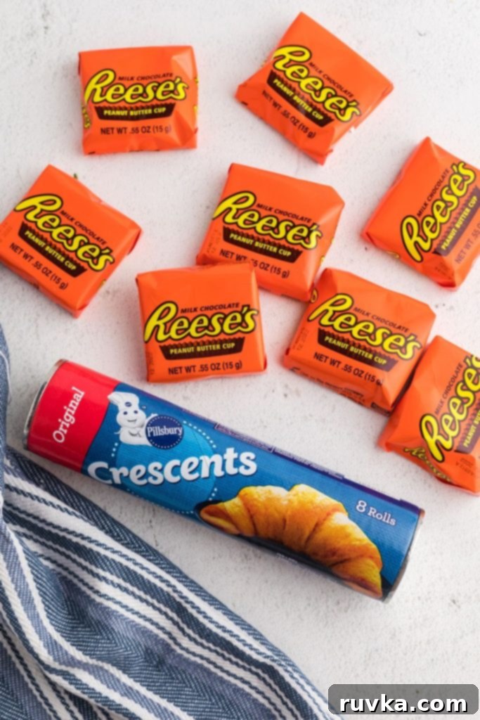 Crispy Air Fryer Peanut Butter Cups 3 Ingredients to make air fried peanut butter cups, of biscuit dough and peanut butter cups on a white marble table.