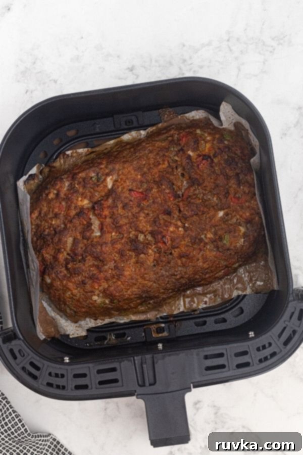 Easy Air Fryer Copycat Cracker Barrel Meatloaf 5 Cooked meatloaf in the air fryer basket.