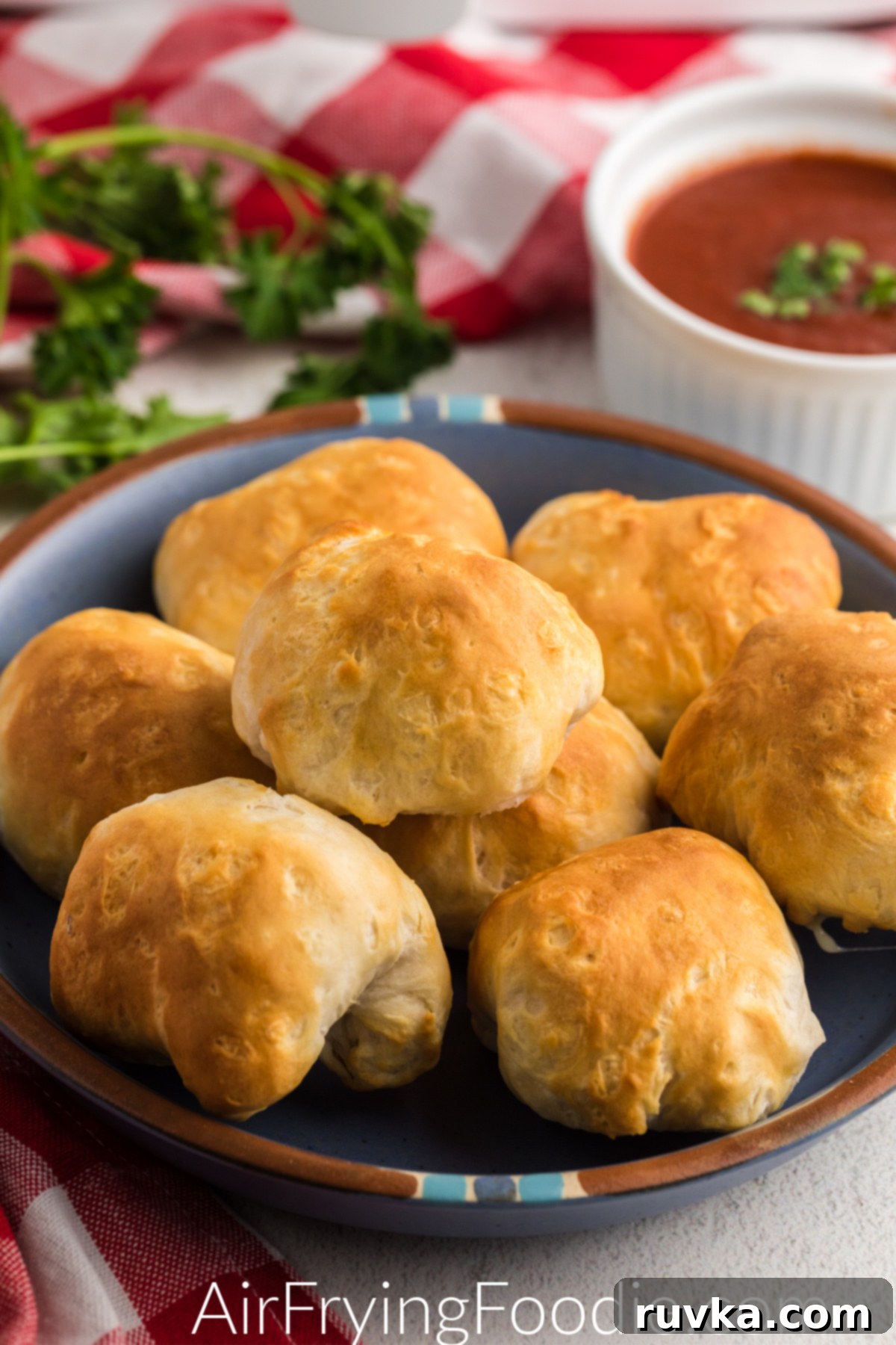 Crispy Air Fryer Mozzarella Balls 2 Air Fryer Mozzarella Balls on a plate with a side of dipping sauce, ready to eat.
