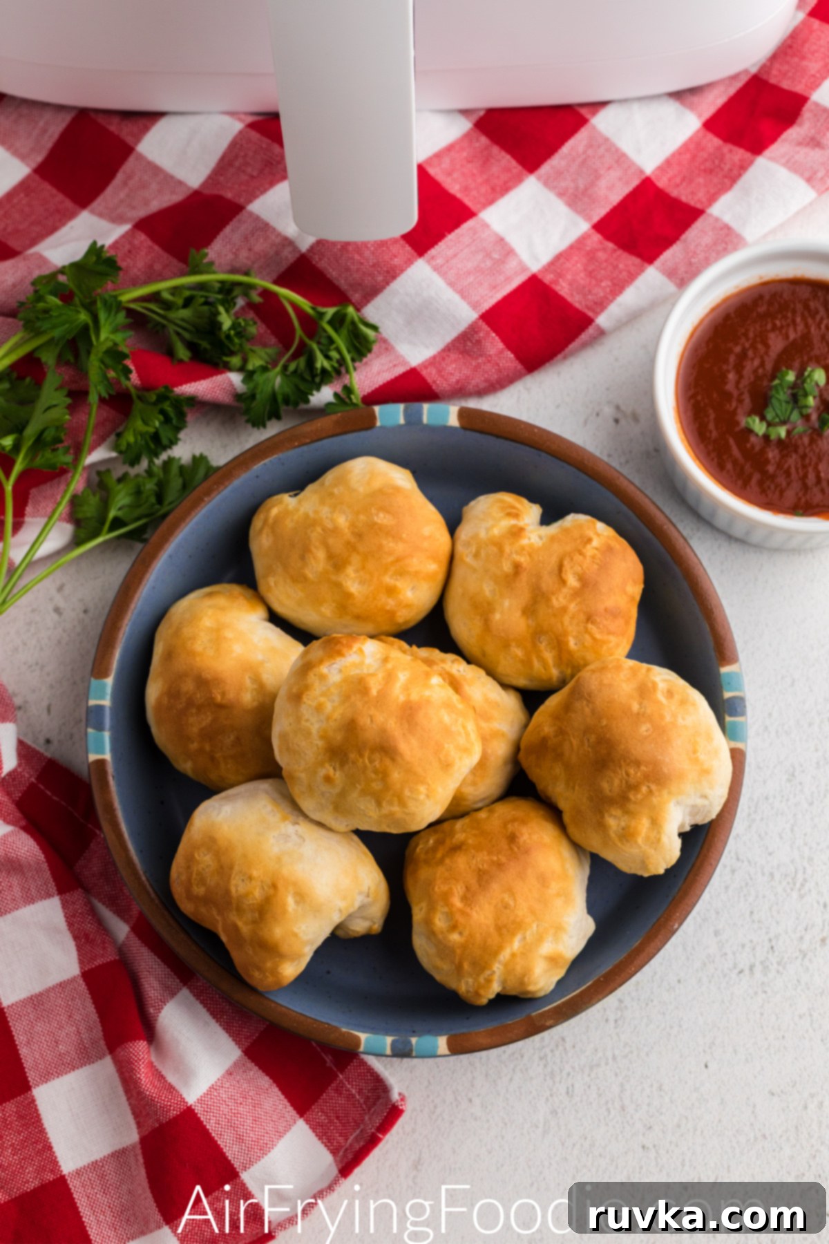Crispy Air Fryer Mozzarella Balls 6 Air fryer mozzarella balls on a blue plate with a side of marinara sauce for dipping.