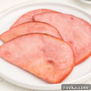 Easy Air Fryer Ham Steak 7 Air fryer ham steaks on a white plate and ready to serve.