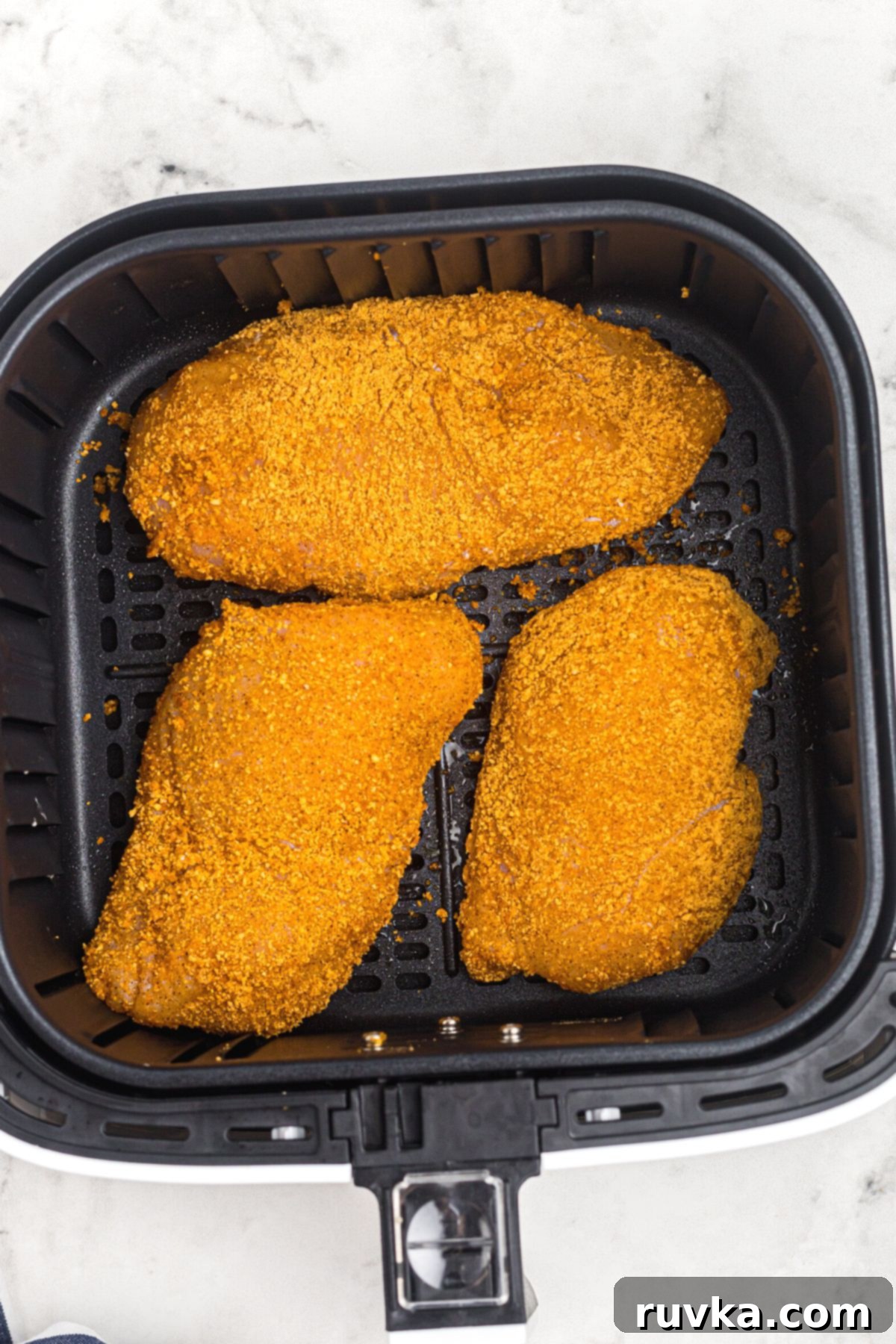Perfectly Crispy Air Fryer Shake and Bake Chicken 6 Golden crispy coated chicken in the air fryer basket before being cooked