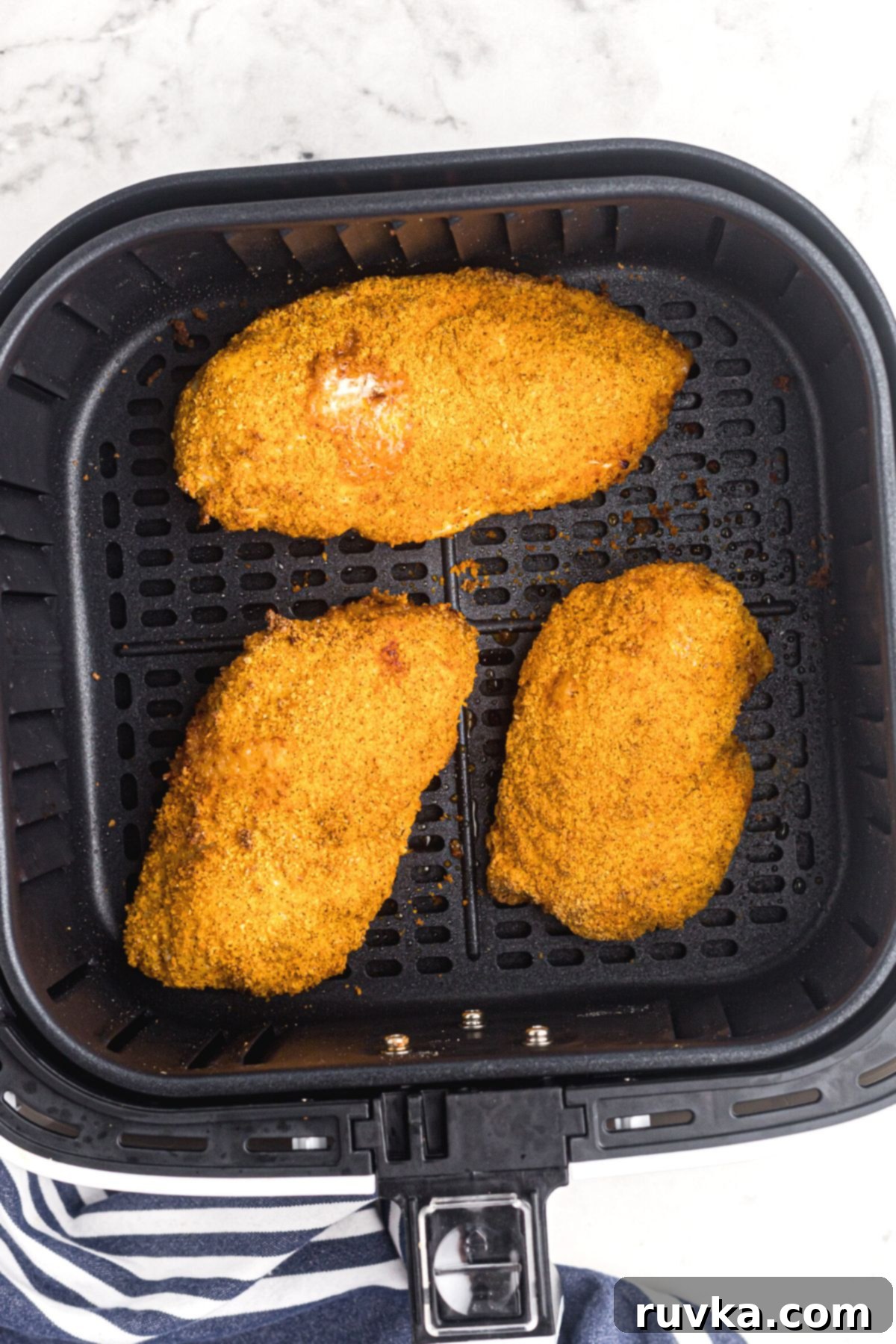 Perfectly Crispy Air Fryer Shake and Bake Chicken 7 Crispy chicken coated with seasonings in the air fryer basket after being cooked