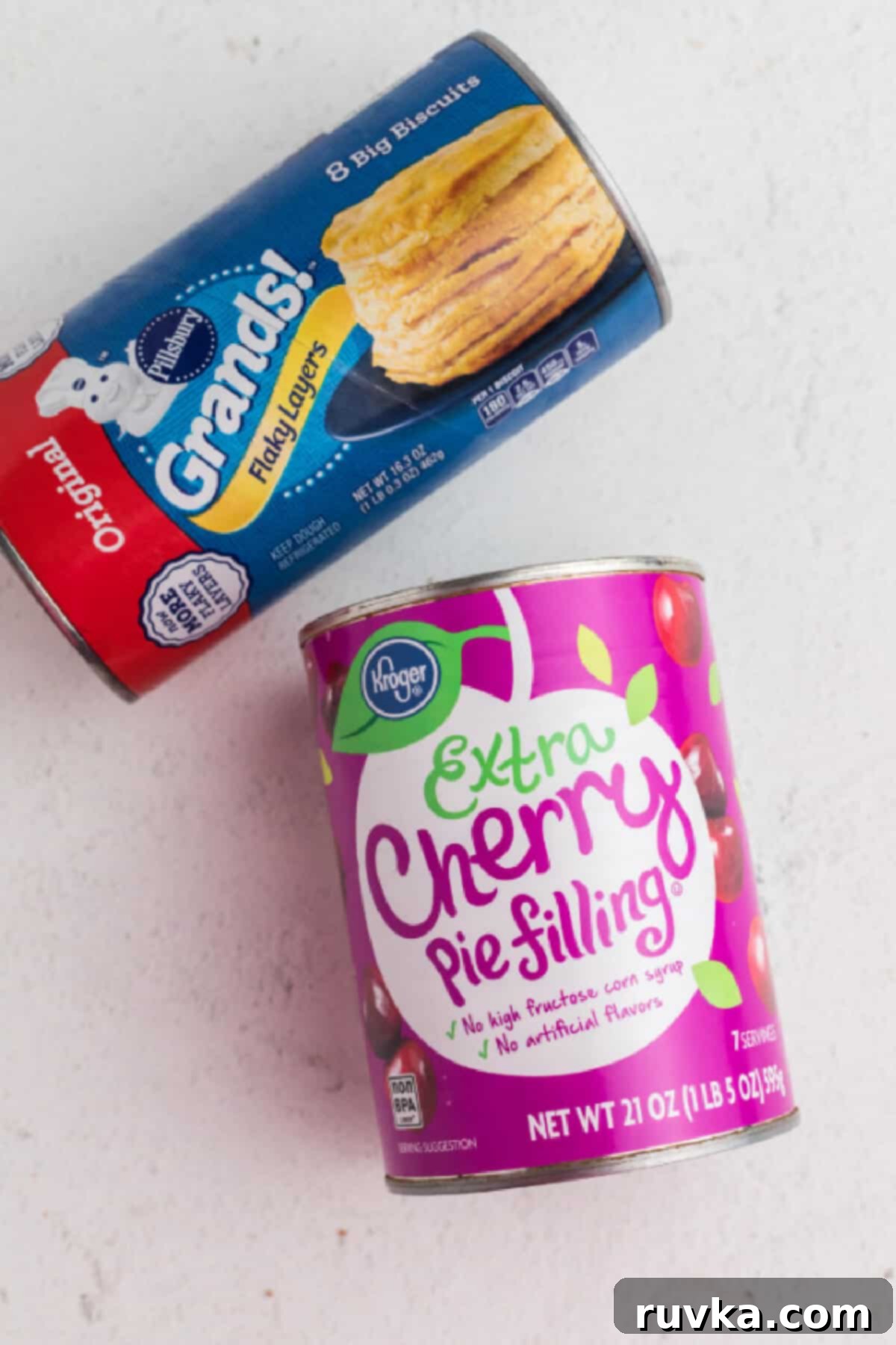 Air Fryer Cherry Pie Bites 3 A can of biscuits and a can of cherry pie filling on a table.