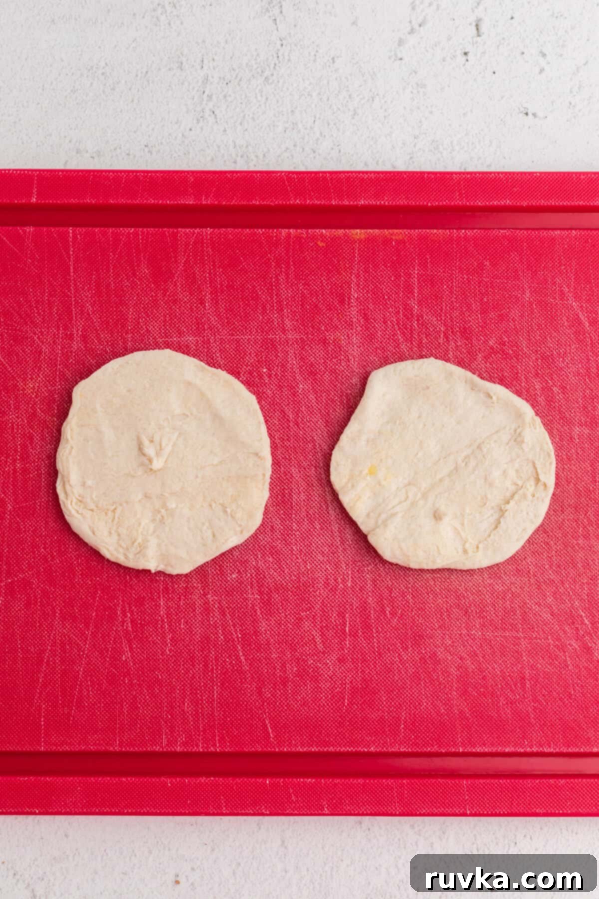 Air Fryer Cherry Pie Bites 4 A biscuit broken in half and rolled out onto a cutting board.