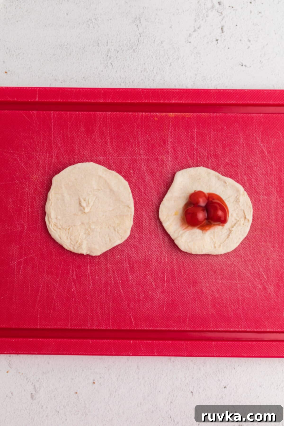 Air Fryer Cherry Pie Bites 5 Pie filling scooped onto a piece of rolled out biscuit dough.