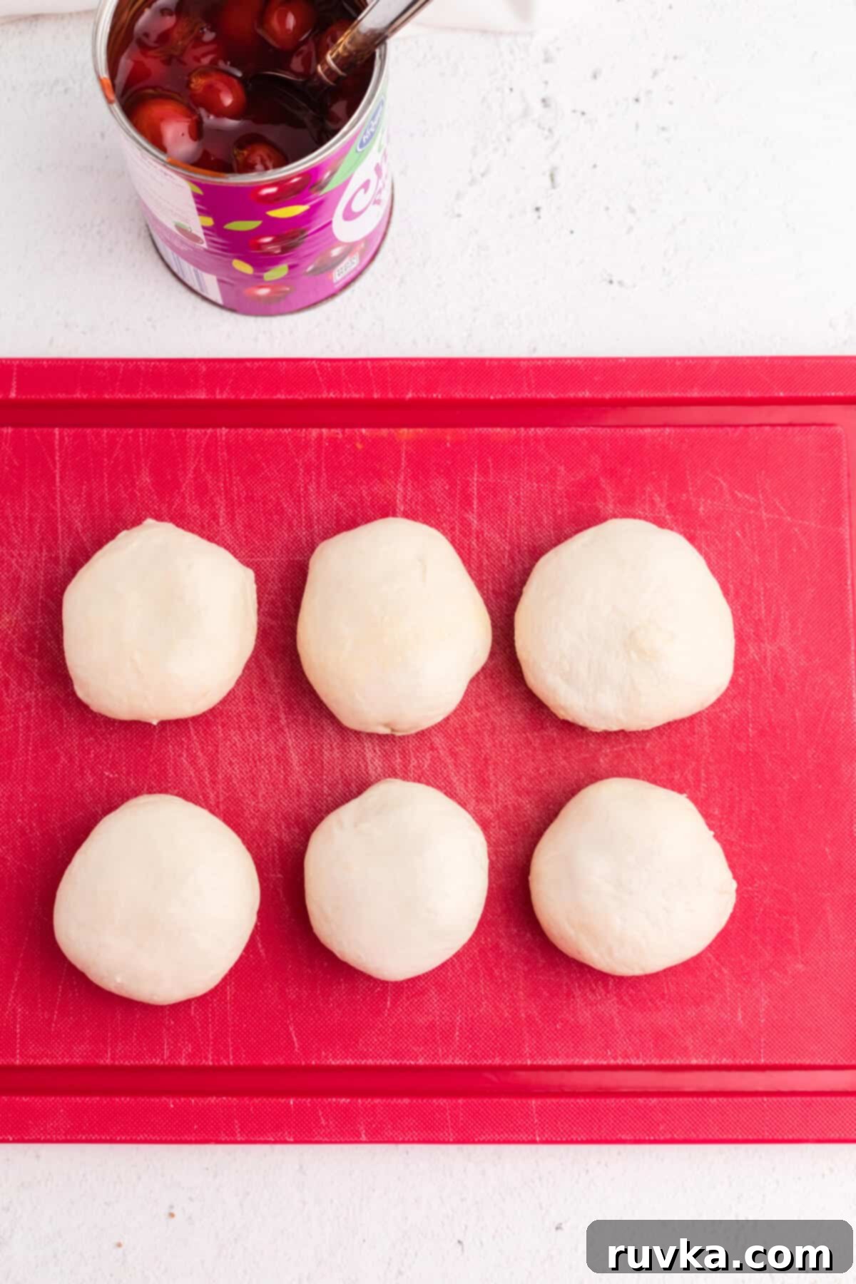 Air Fryer Cherry Pie Bites 6 biscuit dough covering cherry pie filling to make cherry pie bombs.