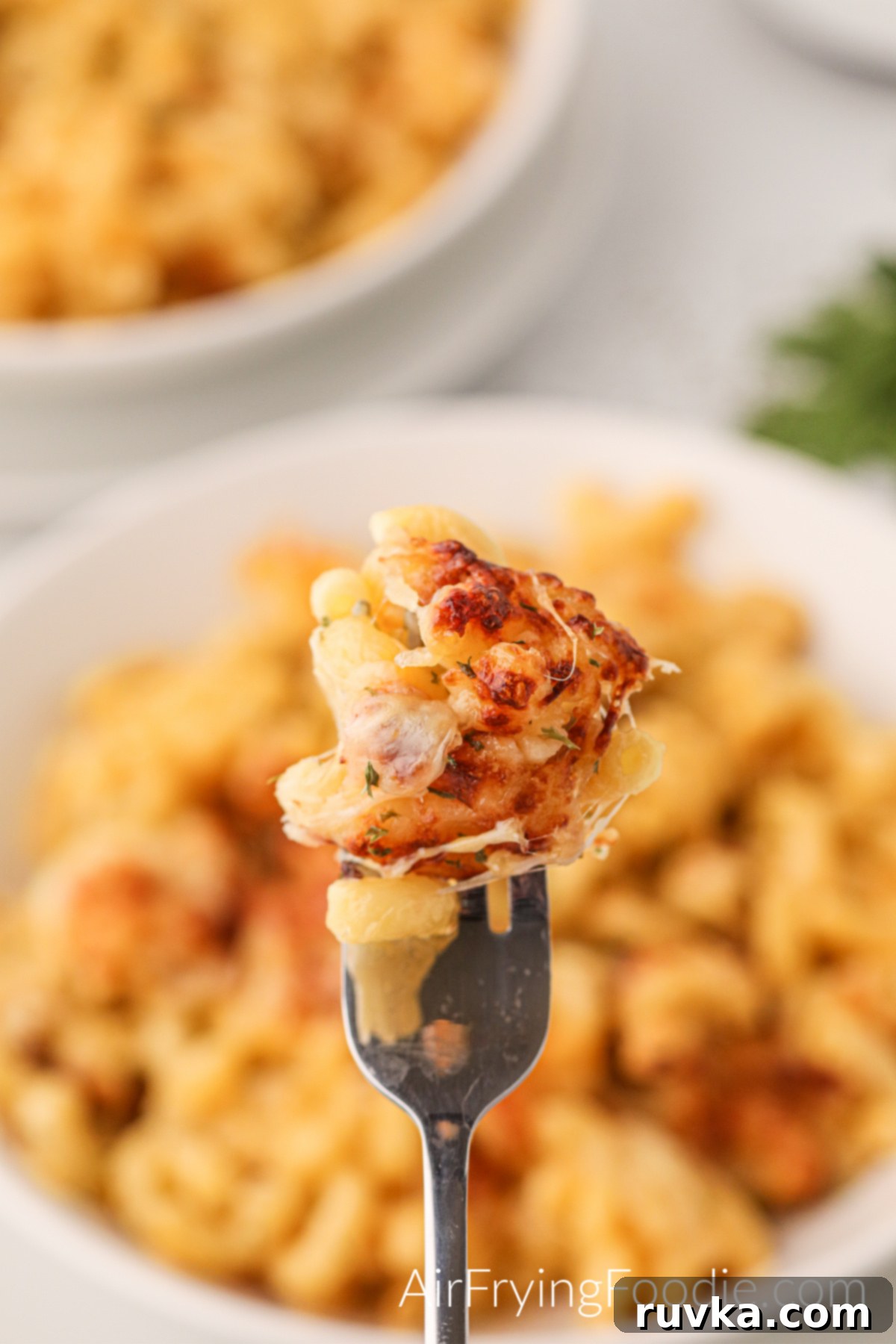 Crispy Air Fryer Mac and Cheese 2 Bite of mac and cheese made in the air fryer on a fork, ready to eat.