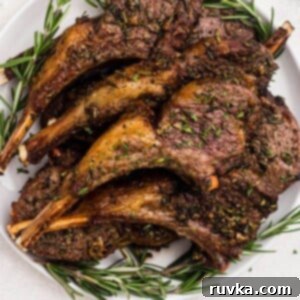 Effortless Easter with Your Air Fryer 17 Golden brown and juicy lamb chops stacked on a white plate.